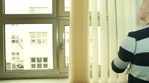 Man opening and turning vertical blinds on the office window Stock Footage 22282777