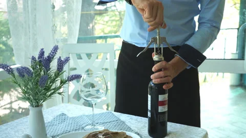 Man opening bottle of wine with corkscrew Stock Footage 92145462