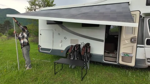 Man opening camper van retractable awning for camping Stock Footage 341570054