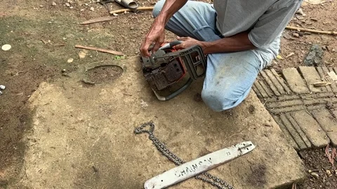 Man opening a chainsaw to repair Stock Footage 326284286
