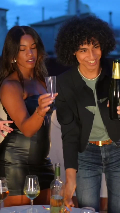 Man opening a champagne bottle celebrating night party with friends Stock Footage 291648849