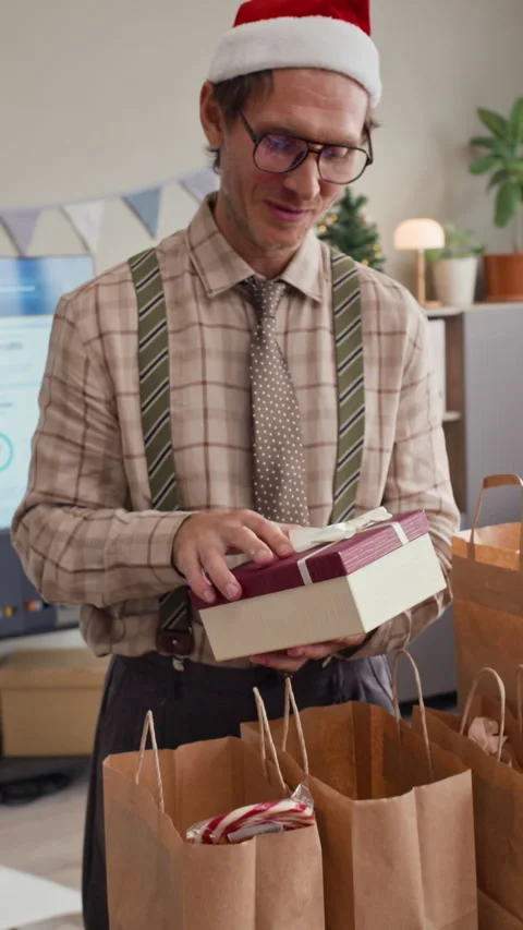 Man Opening Christmas Gift Box with Colleagues at Office Celebration Stock Footage 346055591