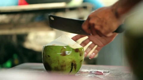 A man opening coconut with a big knife Stock Footage 64254693