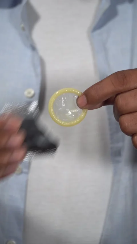 Man opening condom wrapper and showing condom Video stock 314384604