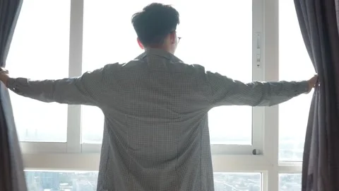 Man opening curtain for sun light in the room Stock Footage 103209845