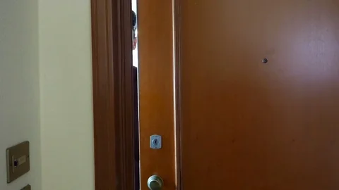 Man opening door and inviting in Stock Footage 78038158