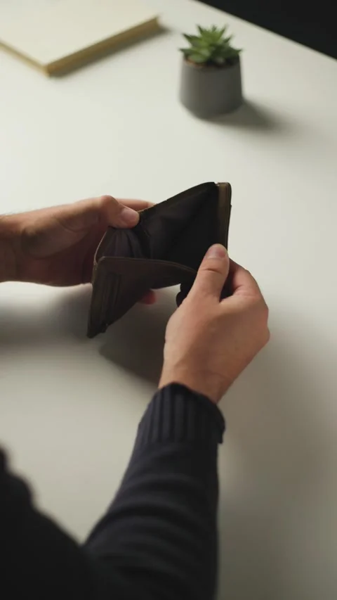 Man Opening Empty Wallet at Desk Overhead Video stock 346809798