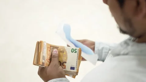 Man opening envelope full of fifty euro banknotes on white background 스톡 동영상 309772782