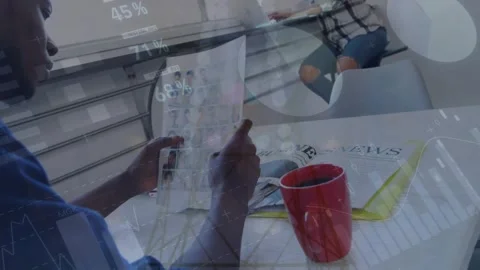 Man opening folded sheet, scanning roster at table while data overlays Stock Footage 326974373