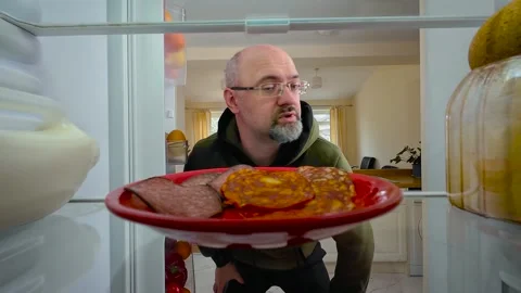 Man opening fridge, finding spoiled sausage and tossing it back with disgusted Stock Footage 324960413
