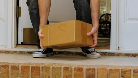 Man opening front door and picking up package delivered to the doorstep. Stock Footage 116995091