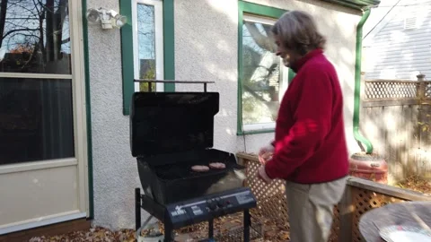 A man opening his BBQ cooking hamburgers  zoom 4K Stock Footage 142277516
