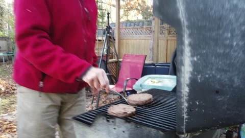 A man opening his BBQ cooking hamburgers  tracking close up  4K Stock Footage 142277544