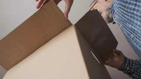 Man Opening Large Cardboard Box from Unique Low Angle Perspective Stock Footage 309098755