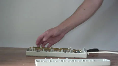 Man opening a plastic casing of an old power strip close up Stock Footage 340404533