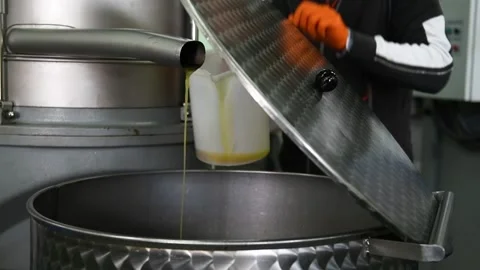 A man is opening  a recipient with fresh olive oil, slow motion Stock Footage 140218337