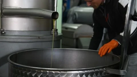 A man in opening a recipient with fresh olive oil Stock Footage 140218401