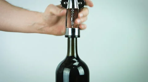 Man opening a red wine bottle ona white background Stock Footage 62910603