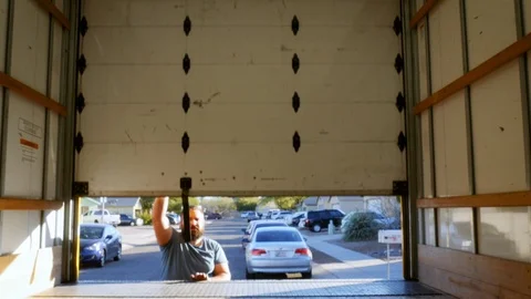 Man Opening Roll-up Sliding Door on a Moving Truck in 4k Vidéo 89296352