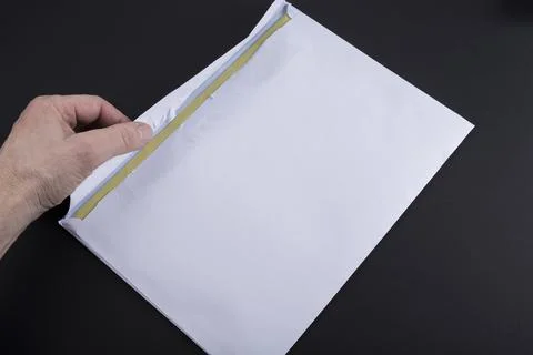 A man is opening white envelope on a black background Stock Photos