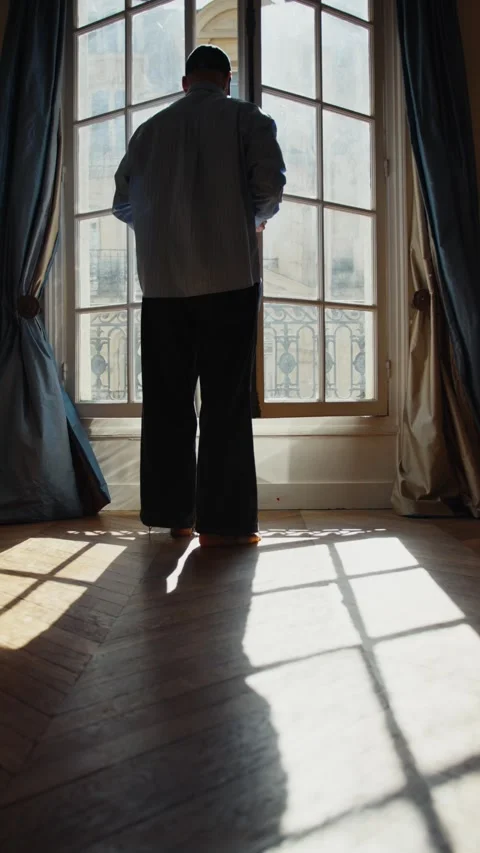 Man opening a window and looking at the city Stock Footage 318728552