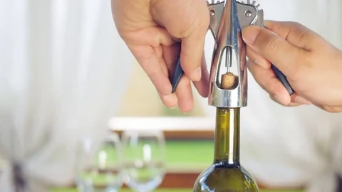 Man opening a wine bottle with a corkscrew . Stockbeeldmateriaal 77438209