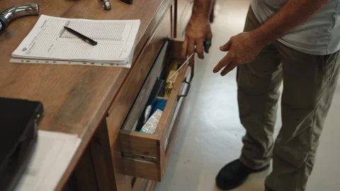 Man opening a wooden drawer at a workshop desk Stock Footage 346183171