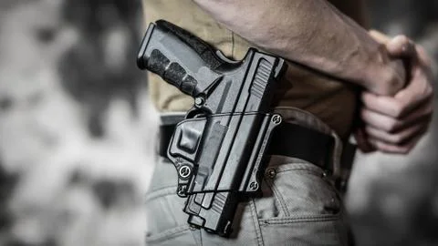 Man openly carrying a .45 handgun on his belt Stock Photos