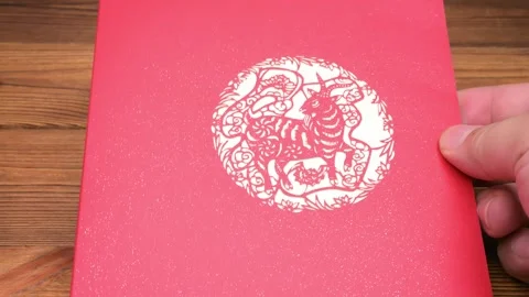 Man opens a 3D pop-up greeting card with delicate Chinese paper-cut style 動画素材 346041397