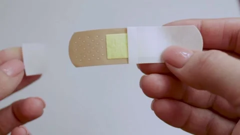 A man opens a Adhesive plaster. Stock Footage 221357090