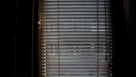 A man opens and closes the blinds. Blinds open and close. Stock Footage 127801631