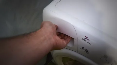 Man opens and closes detergent drawer of washing machine in bathroom of Stock Footage 344094411