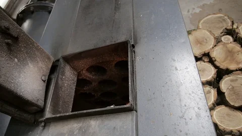 The man opens and closes the door of a wood-fired boiler Stock Footage 73483494