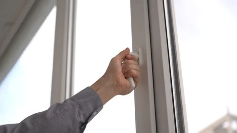A man opens and closes a white plastic window by the handle. Stock Footage 129326229