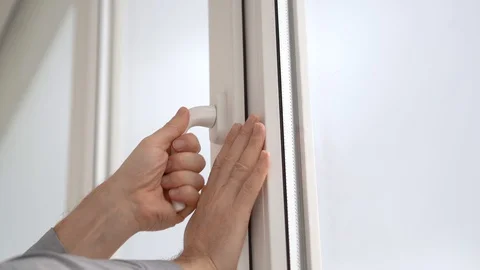 A man opens and closes a white plastic window by the handle. Stock Footage 129326252