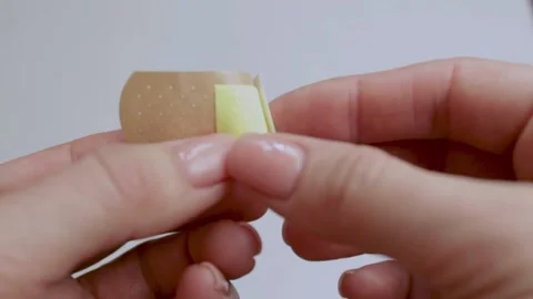 A man opens a band-aid. First aid for trauma. The medicine. Stock Footage 221233588