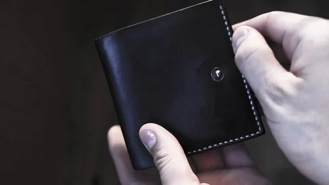 A man opens a black leather wallet with no money at all Stock Footage 129612821