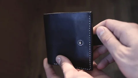 A man opens a black leather wallet with no money at all Stockbeeldmateriaal 129612827