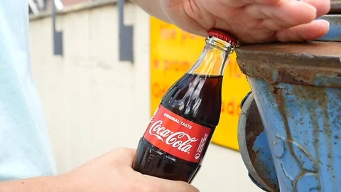 Man opens a Bottle of Coca Cola Soda Drink on a Street Stock Footage 113797384