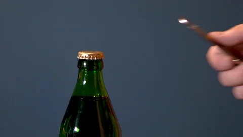 Man opens bottle with fizzy drink with a special opener. Glass bottle with metal Stock Footage 113215436