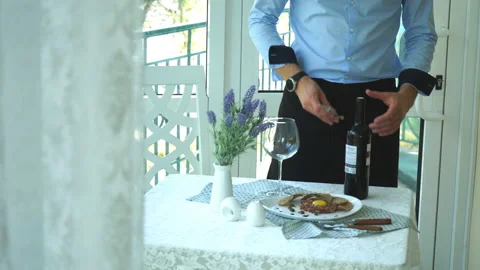 A man opens a bottle of red wine in a restaurant Stock Footage 92144591