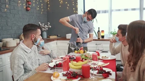 A man opens a bottle of red wine in the company of friends. All have protective Stock Footage 147435407