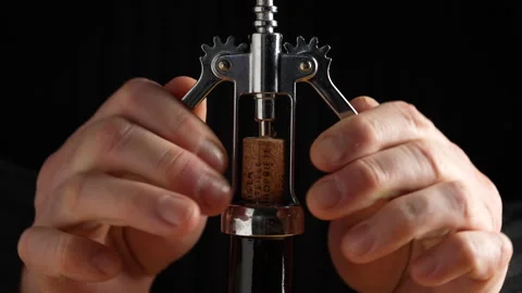 Man opens a bottle of red wine. Opening a glass wine bottle with corkscrew Stock Footage 302644560