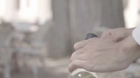 A man opens a bottle of wine with a corkscrew, closeup Stock Footage 135398396
