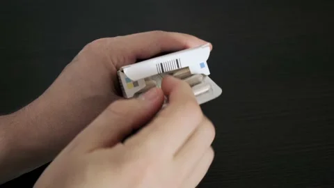 The man opens the box and takes out a blister with medical pills. The topic of h Stock Footage 232154709
