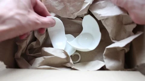 Man opens a box with a broken cup, dishes. Concept of careless transportation of Stock Footage 194249741