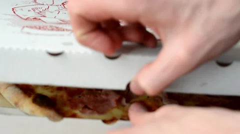 Man opens box with pizza and takes one slice and eats 動画素材 49853867