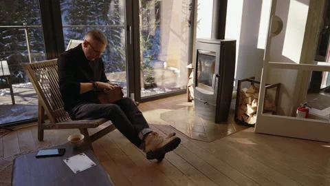 A man opens a box while sitting in the living room Stock Footage 265104843