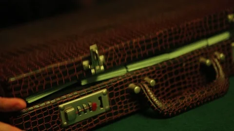 Man opens briefcase full of 100 dollars currency notes in a dimly lit nightcl Stock-Footage 230235337