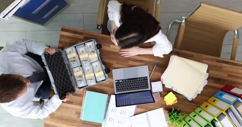 Man opens briefcase with money while woman gesturing in shock Stock Footage 312929713